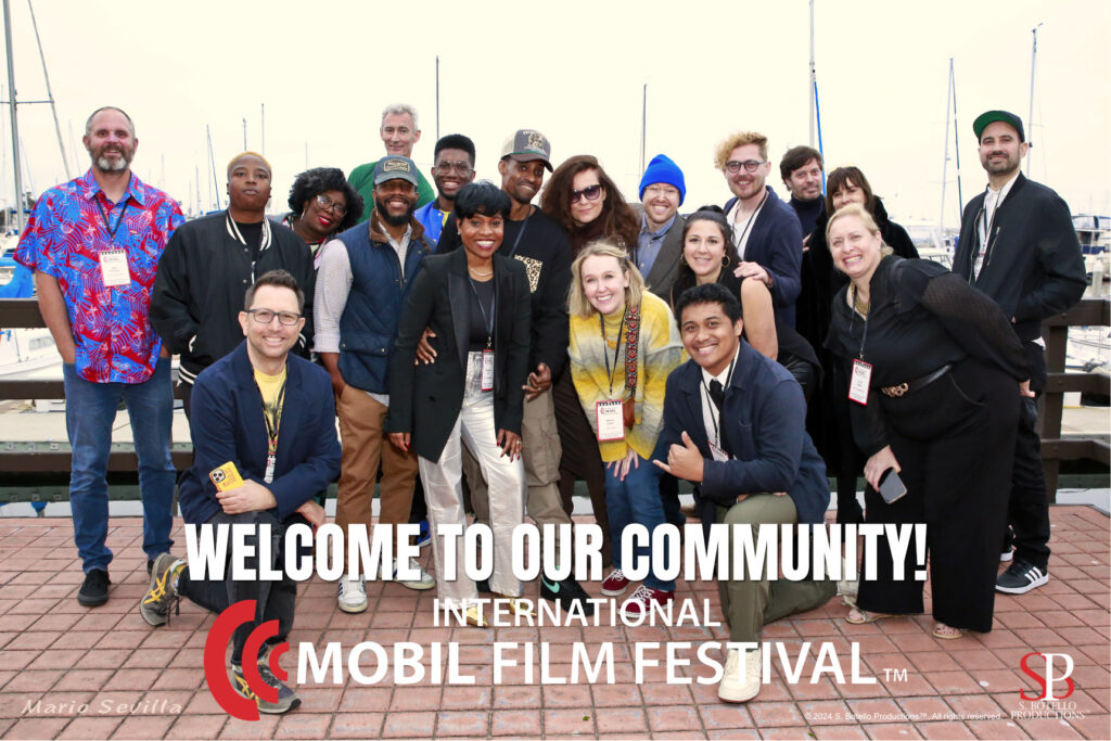 large group of filmmakers pose in front of a marina.