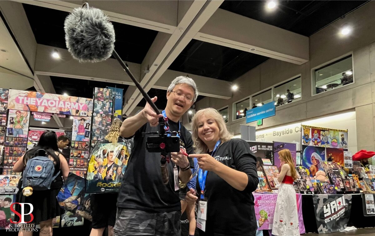 Image of two people showing smartphone video gear inside comic convention.